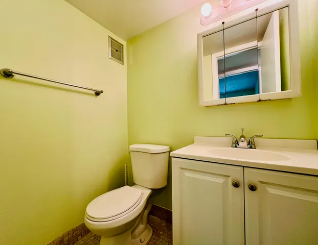 a bathroom with a sink and mirror with toilet