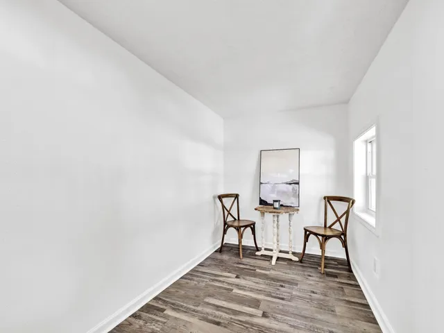 a view of a livingroom with chairs and wooden floor