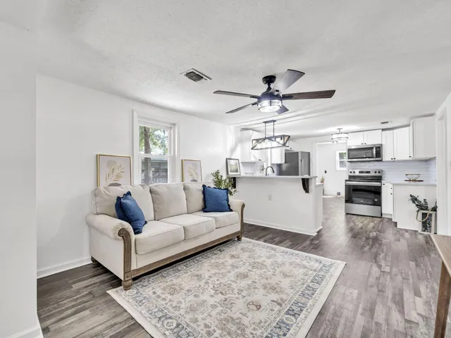 a living room with furniture and kitchen view