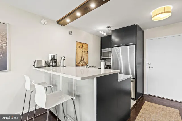 a kitchen with stainless steel appliances a refrigerator and a table