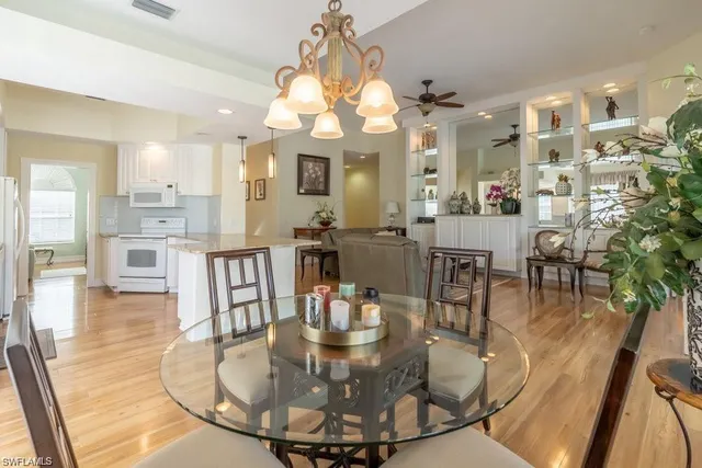 a view of a dining room with furniture a chandelier and wooden floor