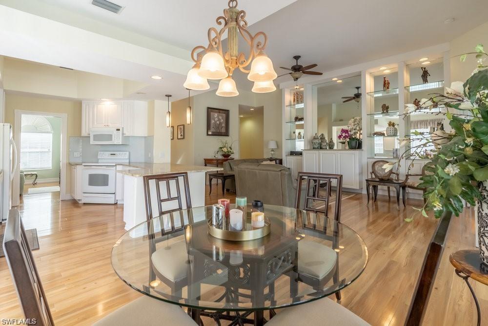 a view of a dining room with furniture a chandelier and wooden floor