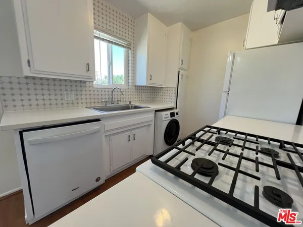 a kitchen with a sink a stove and cabinets