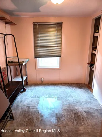 a view of an empty room with window and stairs