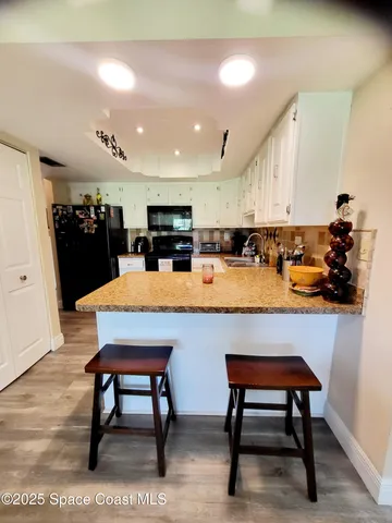 a kitchen with a table chairs refrigerator and microwave