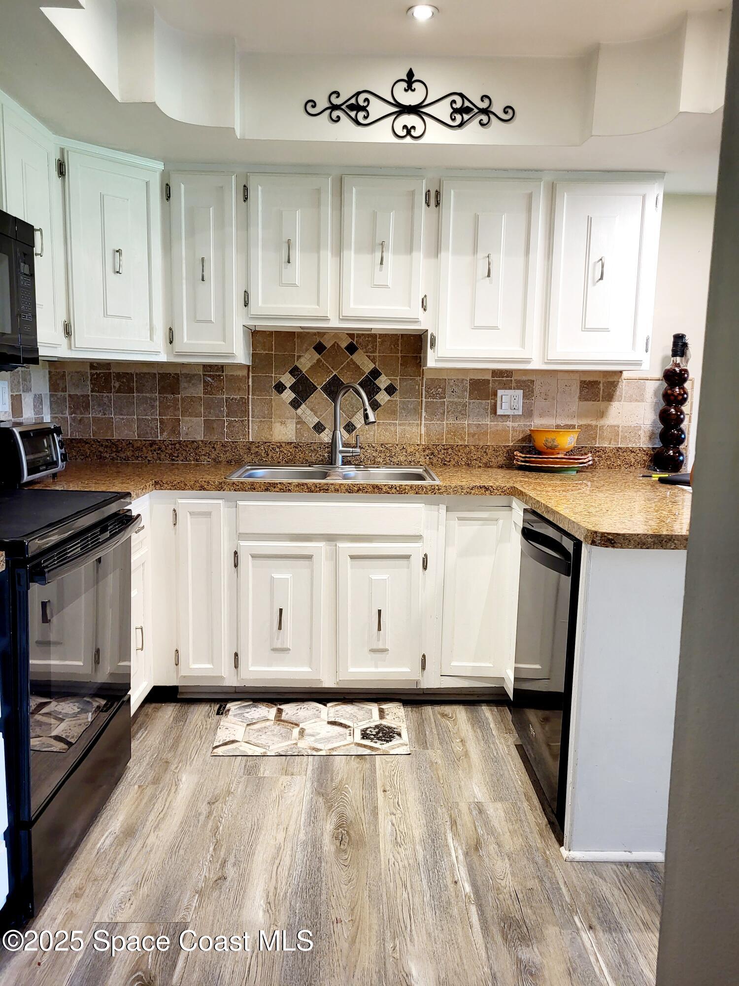 145 Augusta Way Melbourne, FL 32940 - Photo 13 of 28 a kitchen with a stove top oven sink and cabinets