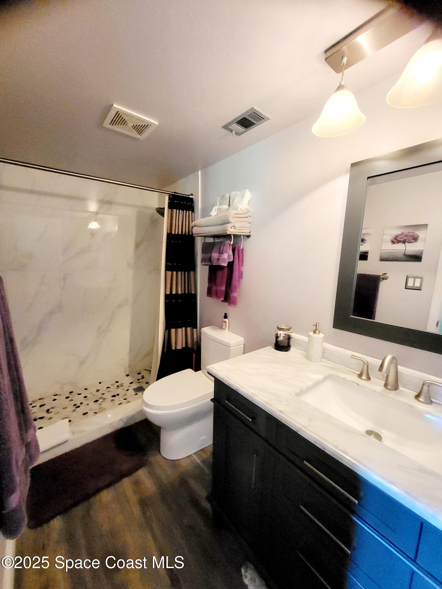 145 Augusta Way Melbourne, FL 32940 - Photo 17 of 28 a bathroom with a sink a toilet and shower