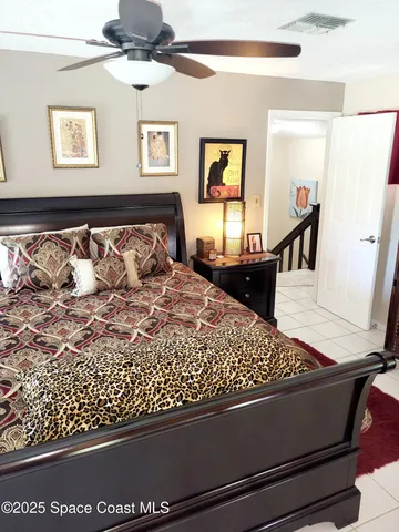 a bed sitting in a bedroom next to a window with a chandelier