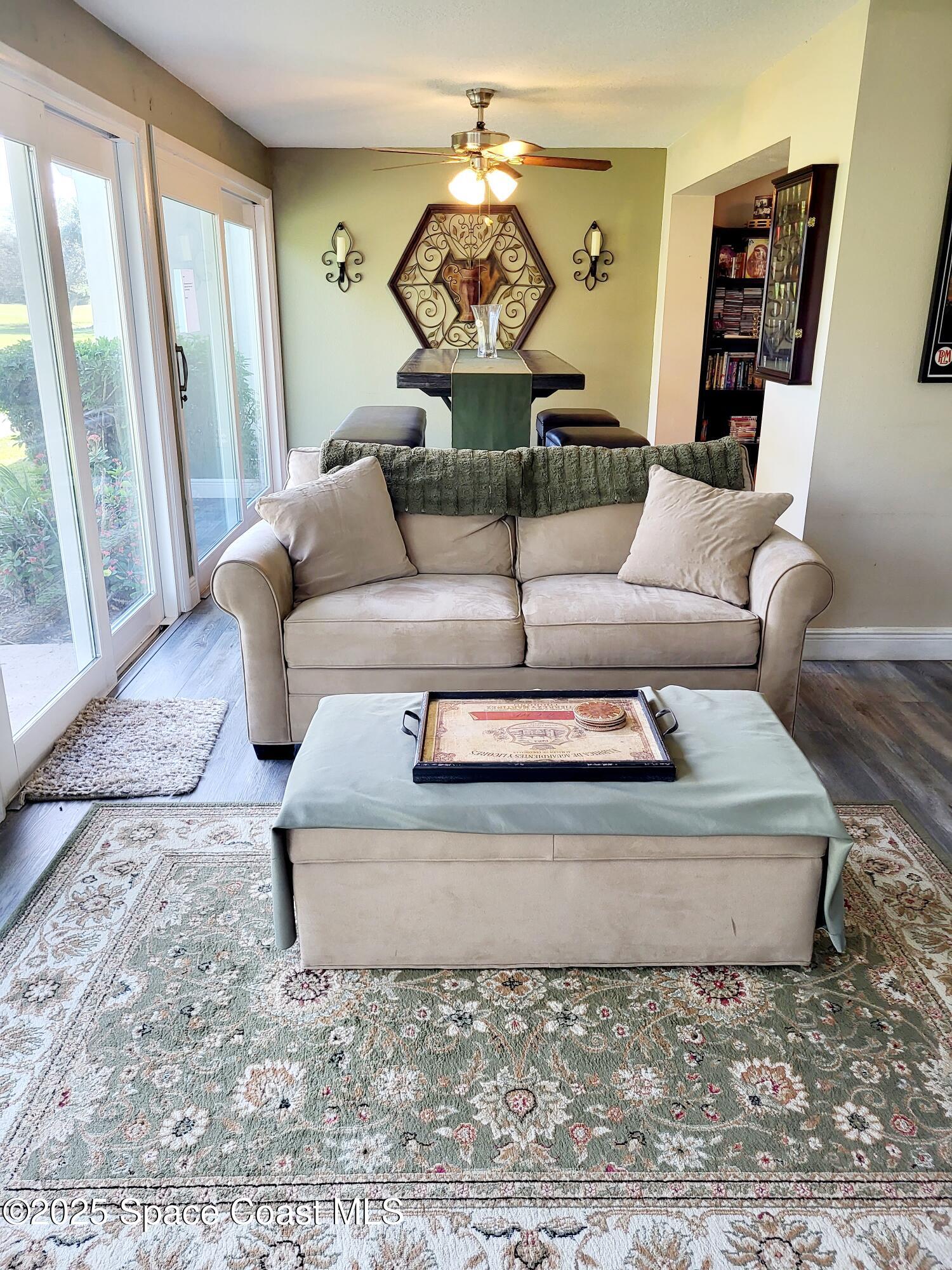 145 Augusta Way Melbourne, FL 32940 - Photo 10 of 28 a living room with furniture and a floor to ceiling window