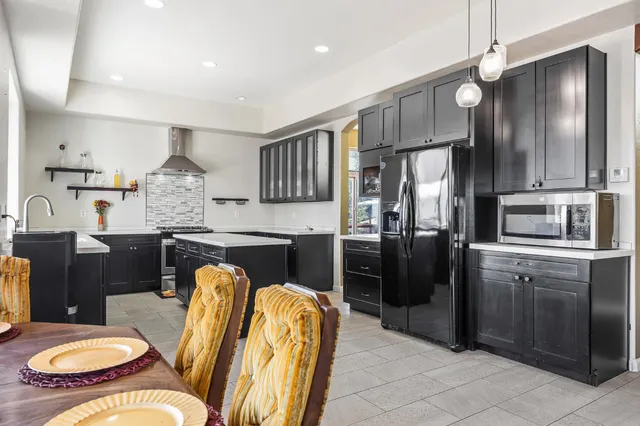a kitchen with a large counter top space appliances and windows