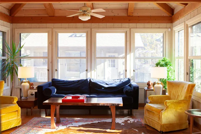 a living room with furniture and floor to ceiling windows