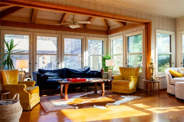 a living room filled with furniture and floor to ceiling windows