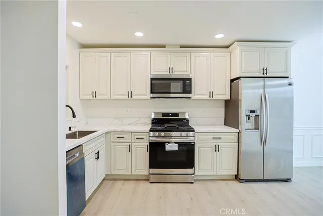 a kitchen with cabinets stainless steel appliances and a counter space