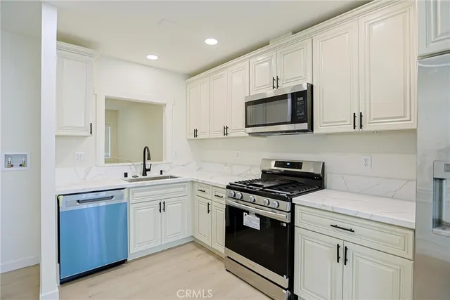 a kitchen with stainless steel appliances a refrigerator sink and stove