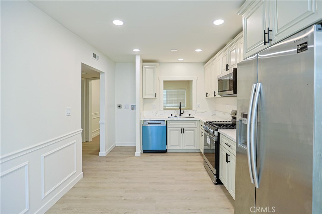 4109 West 5th Street, Unit F2 Santa Ana, CA 92703 - Photo 17 of 41 a kitchen with stainless steel appliances a refrigerator sink and stove