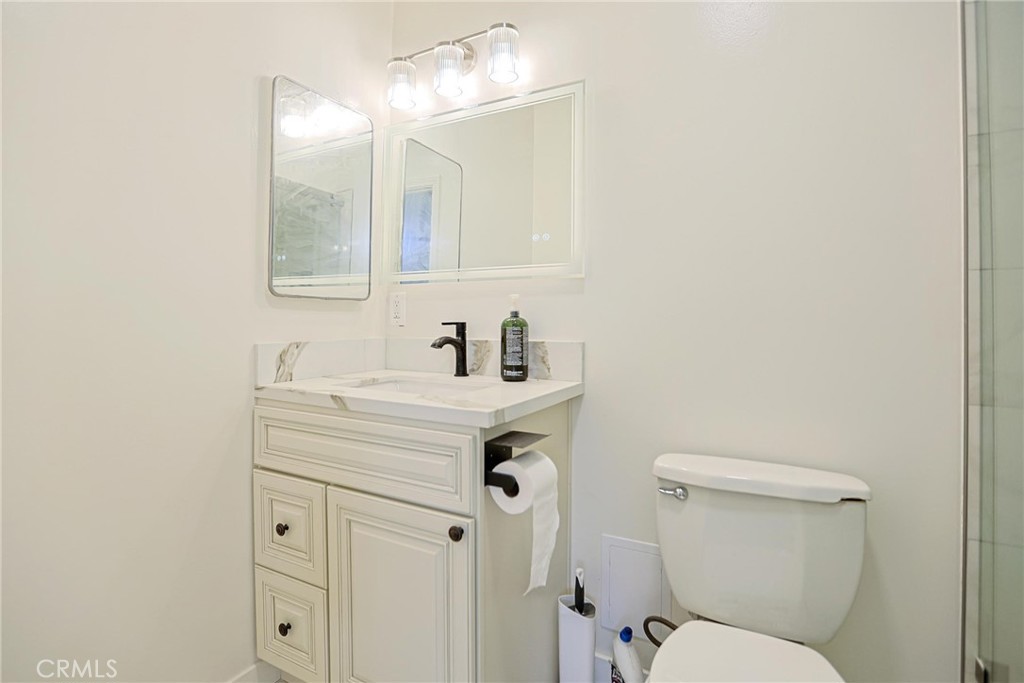 4109 West 5th Street, Unit F2 Santa Ana, CA 92703 - Photo 24 of 41 a bathroom with a sink mirror vanity and toilet