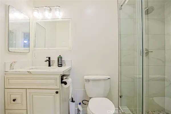 a bathroom with a sink a toilet and shower