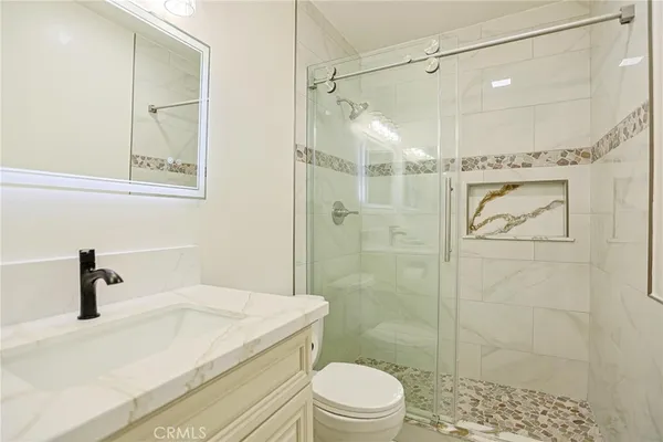 a bathroom with a shower a toilet and sink