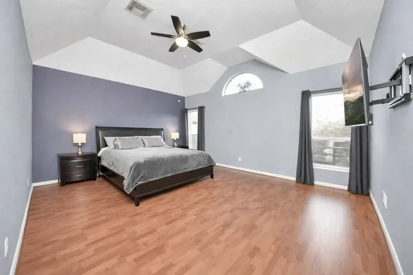 a bedroom with a large bed chandelier and a window