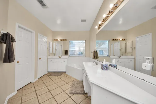 a spacious bathroom with a double vanity sink mirror and shower