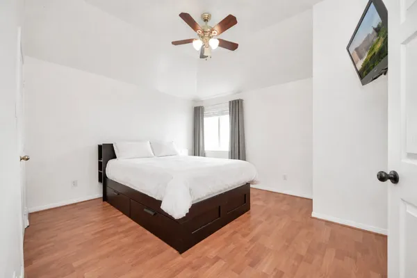 a spacious bedroom with a bed and a chandelier