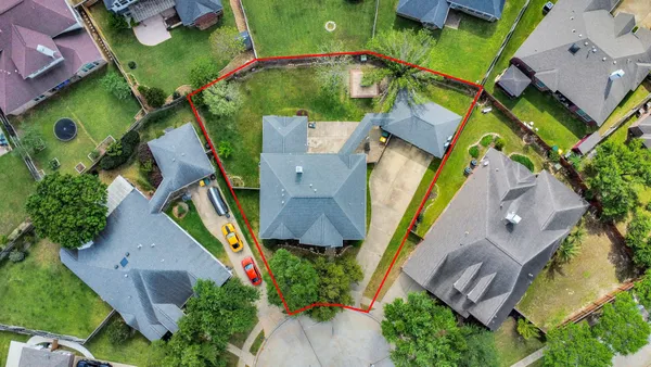 an aerial view of a house with a yard and outdoor seating