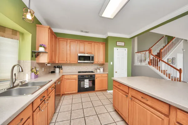 a kitchen with stainless steel appliances a sink dishwasher stove refrigerator and cabinets