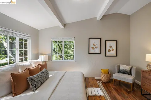a bedroom with bed and paintings on the wall
