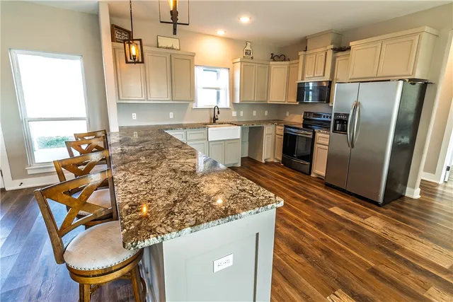 a kitchen with stainless steel appliances granite countertop a sink refrigerator and microwave