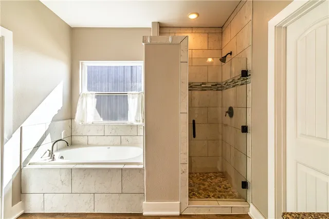 a bathroom with a bathtub and shower