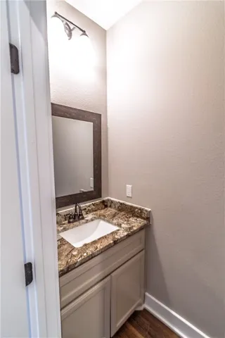 a bathroom with a granite countertop sink and vanity
