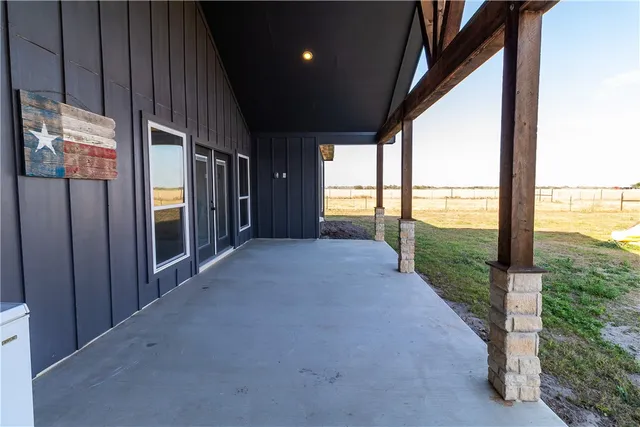 a view of a porch with furniture and floor to ceiling window