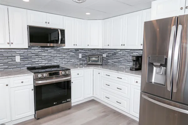 a kitchen with white cabinets stainless steel appliances and sink