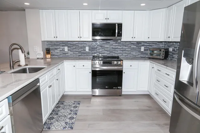 a kitchen with stainless steel appliances granite countertop a stove sink and cabinets