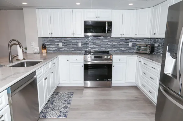 a kitchen with stainless steel appliances granite countertop a stove sink and cabinets