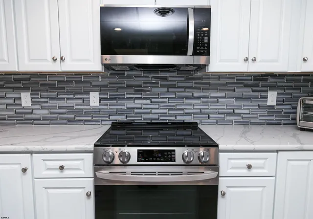 a kitchen with white cabinets and appliances
