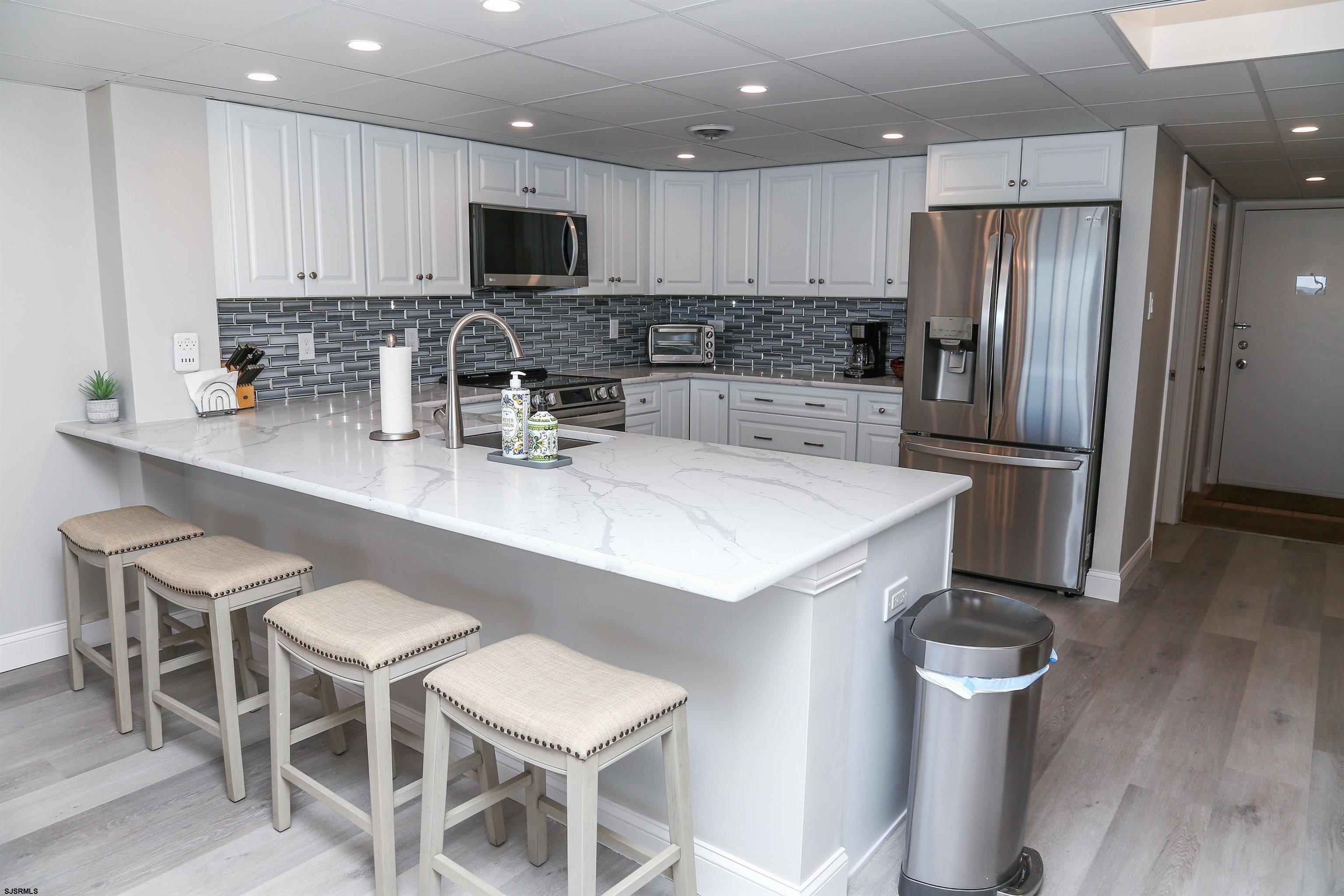 4540 West Brigantine Avenue, Unit N408 Brigantine, NJ 08203 - Photo 9 of 42 a kitchen with stainless steel appliances a microwave a sink and a refrigerator