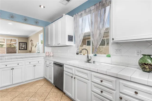 a kitchen with granite countertop white cabinets white appliances and a sink