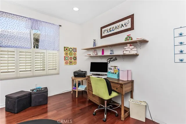 a view of a workspace with furniture and a window