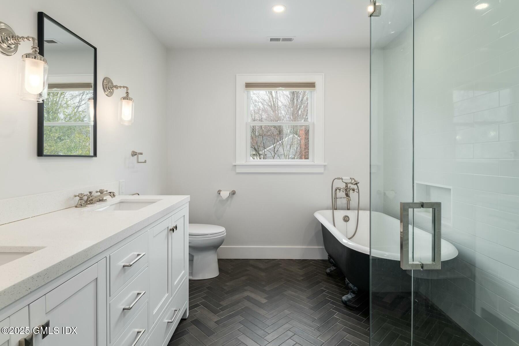 7 Griffith Road Riverside, CT 06878 - Photo 14 of 30 a spacious bathroom with a toilet sink and mirror
