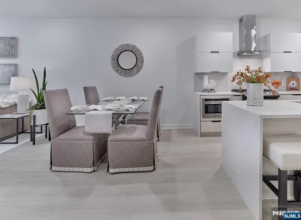 a living room with furniture a table chairs and a kitchen view