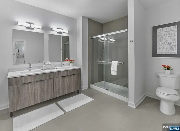 a bathroom with a double vanity sink toilet and shower