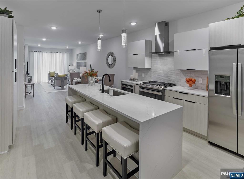 8 Tice Road, Unit 110 Franklin Lakes, NJ 07417 - Photo 3 of 29 a kitchen with stainless steel appliances kitchen island a table chairs sink and cabinets