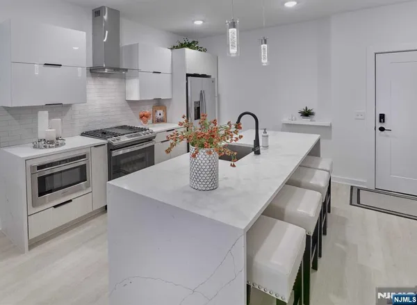 a kitchen with stainless steel appliances granite countertop a sink a stove and a refrigerator