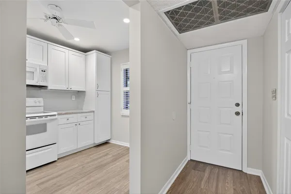 a kitchen with white cabinets and white appliances