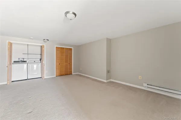 a view of an empty room with a cabinet and a window