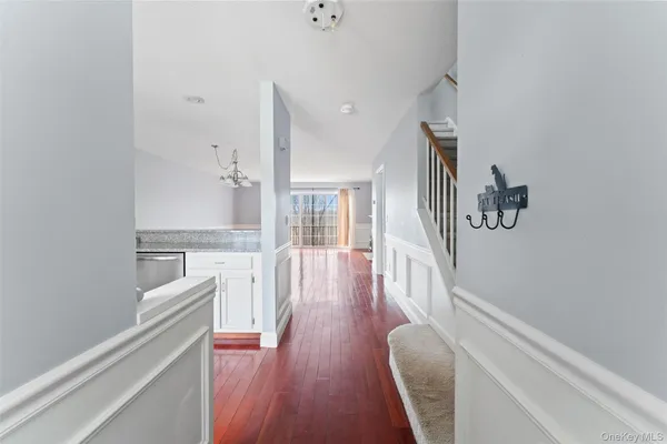 a hallway with white cabinets and wooden floor