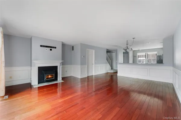 a view of a livingroom with wooden floor and a fireplace