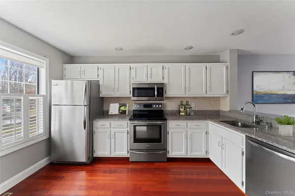 a kitchen with granite countertop a refrigerator stove and microwave