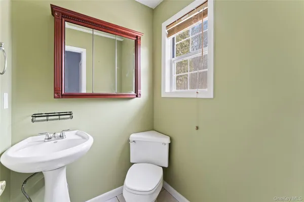 a bathroom with a toilet sink and mirror